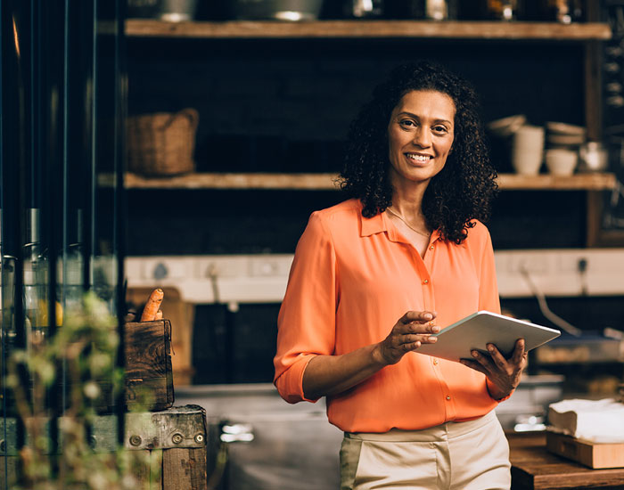 woman standing in a business holding ipad